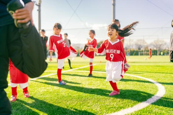 Group of girls in red sports uniform in a football field