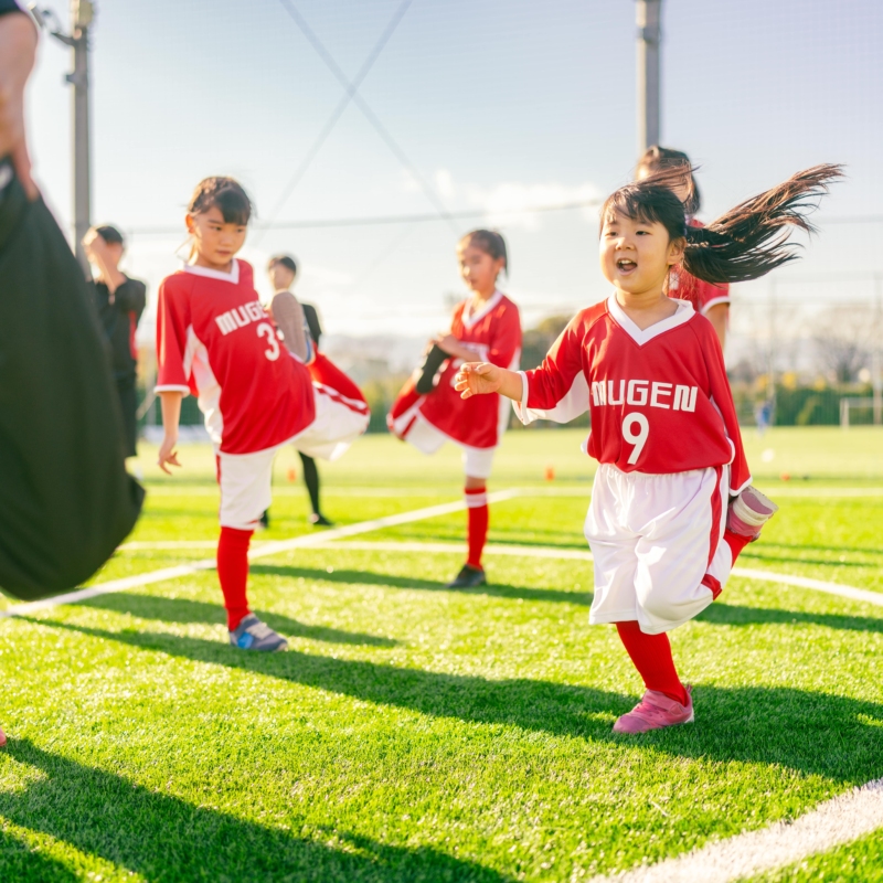 Group of girls in red sports uniform in a football field